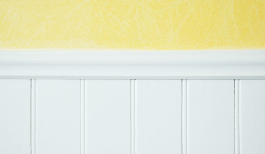 yellow colored wall with white chair rail