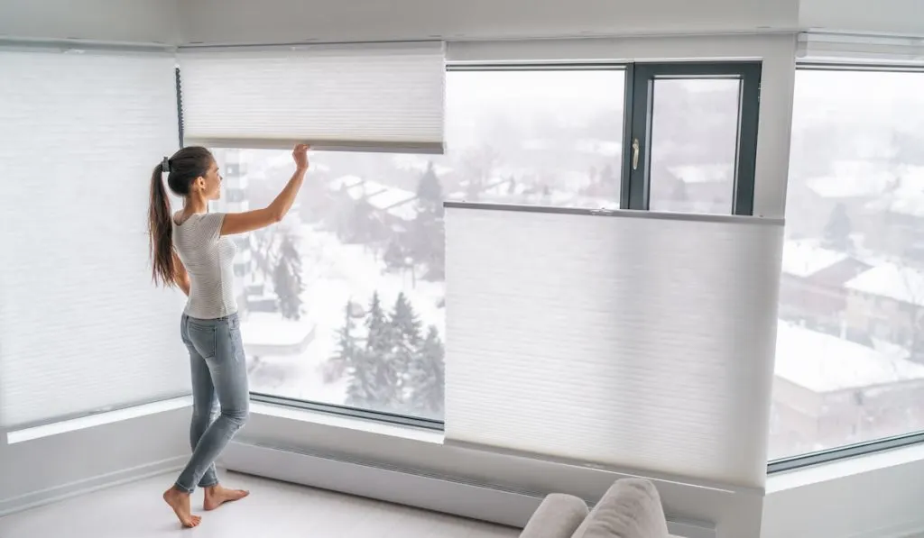 woman pulling down blinds