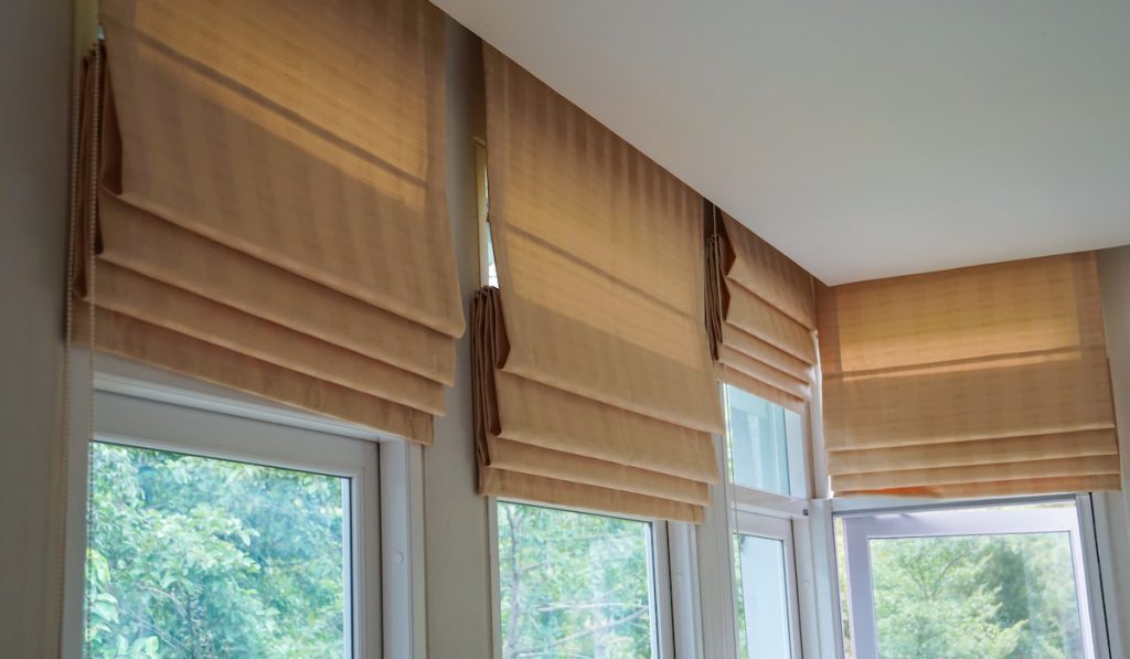 brown roman blinds on the window