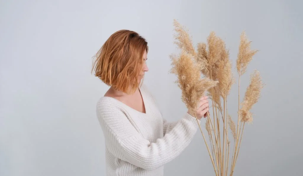 woman tends to pampas grass