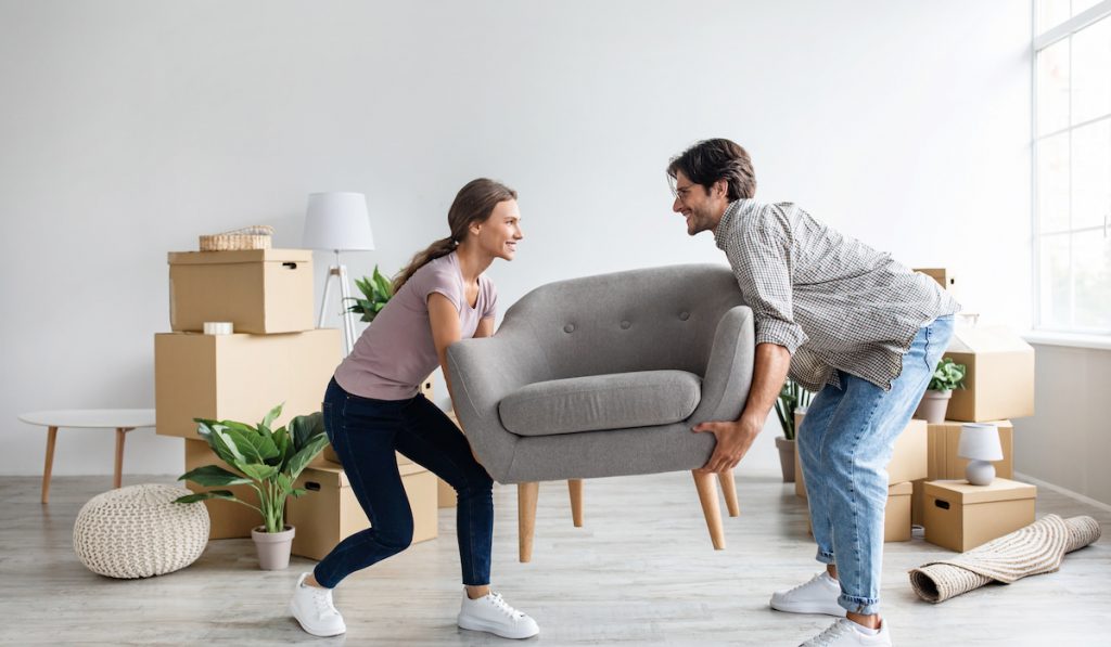 couple moving in carrying their accent chair