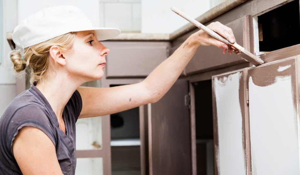 woman painting kitchen cabinet