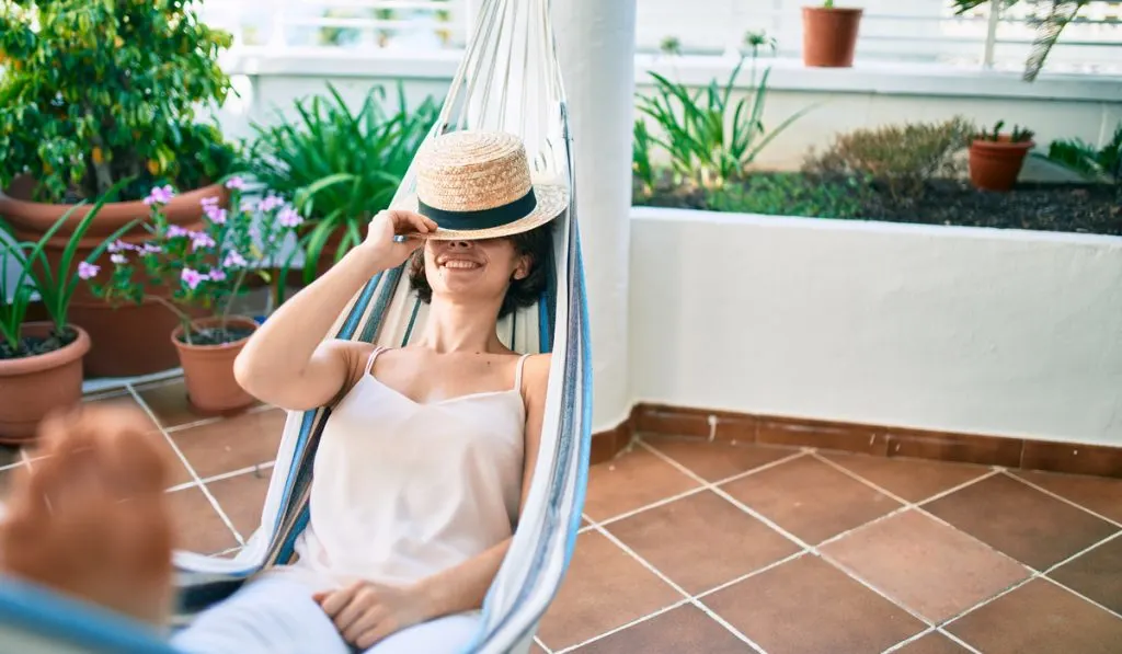 Young beautiful Caucasian woman smiling happy resting on a hammock