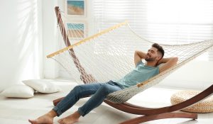 Young-man-relaxing-in-hammock-at-home